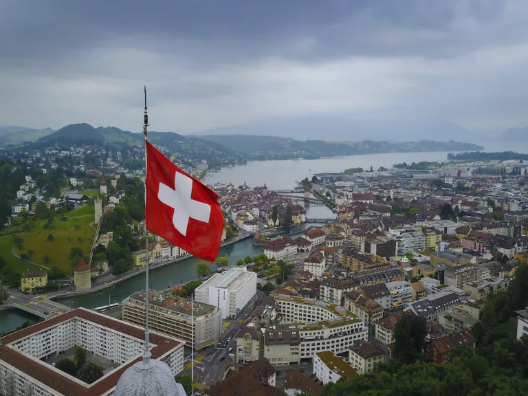 Lucerne, la Reuss et le lac vus en hauteur, avec un drapeau suisse au premier plan.