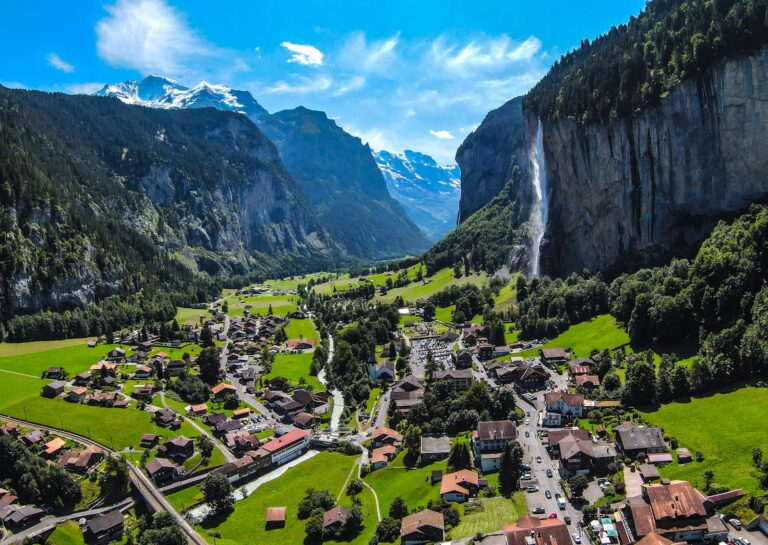 Village de Lauterbrunnen entre des falaises, avec une cascade et des sommets en arrière-plan.
